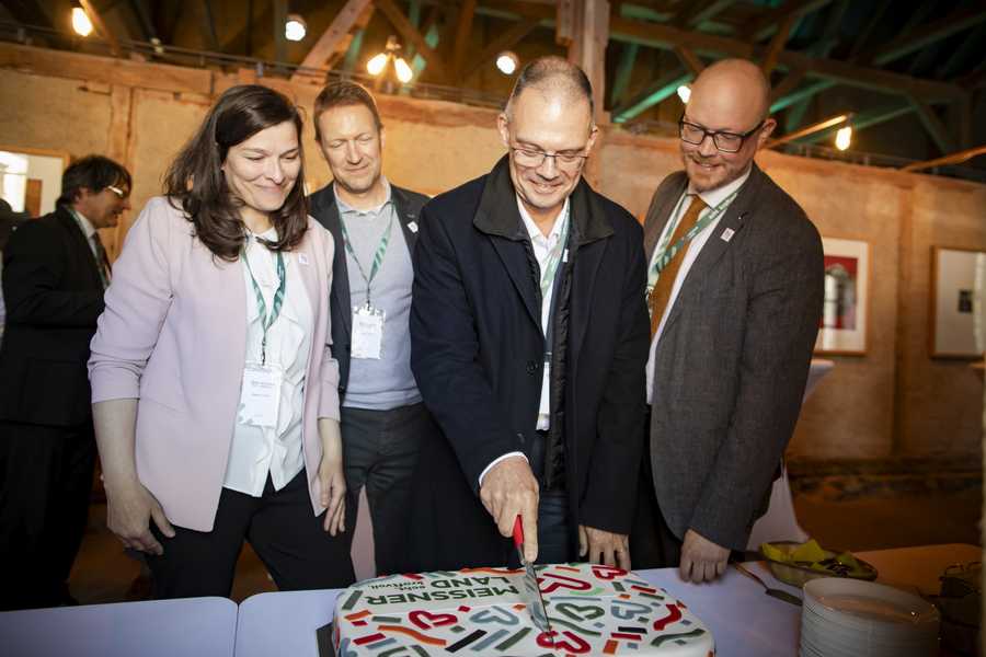 Landrat Ralf Hänsel beim Anschnitt des im Corporate Design gestalteten Markenkuchens